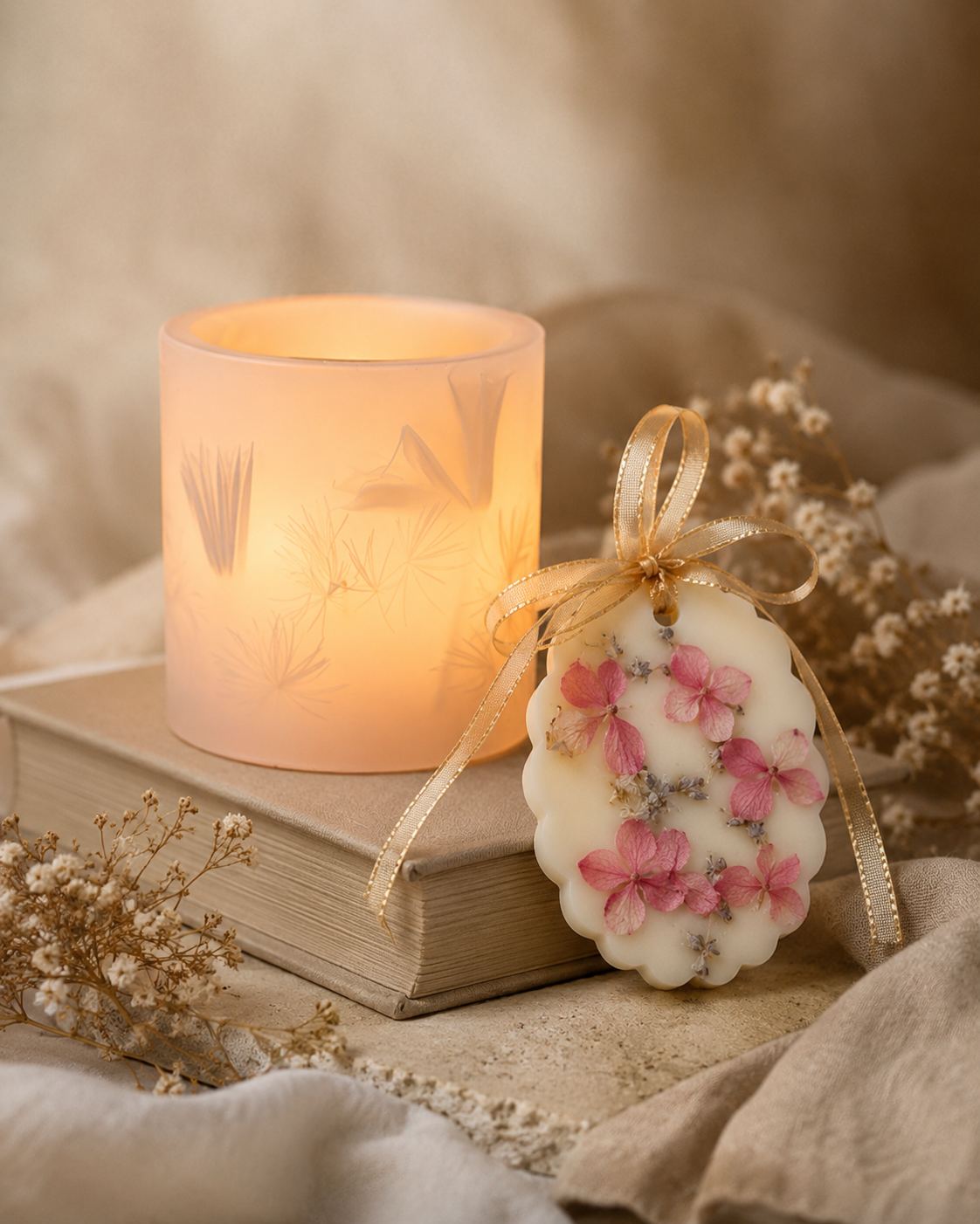 Scentpiece candle and floral wax tablet styled with books and linen